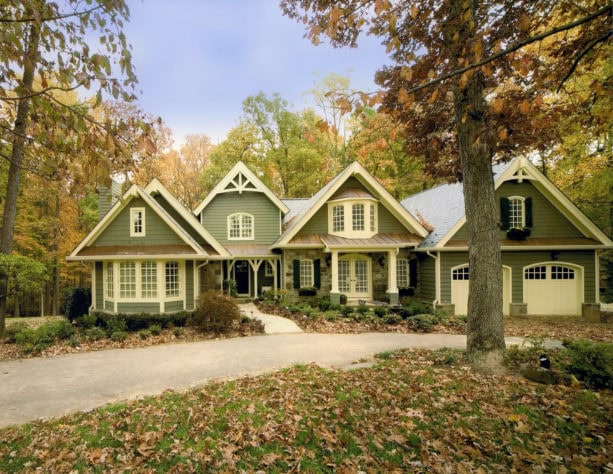 a creamy green vinyl siding exterior in a sizeable ranch style two-story home