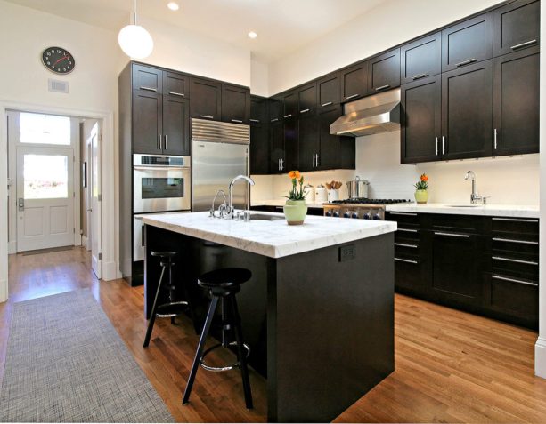 transitional kitchen with dark stained cabinets and white carrara marble countertops