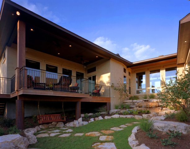 boulder bordered under deck landscaping completed with a wooden swing