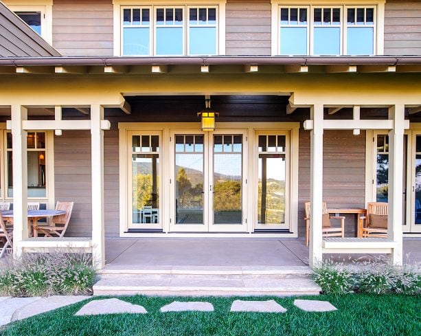 aluminum exterior with beige trim that matches the windows against the brown siding of a craftsman house