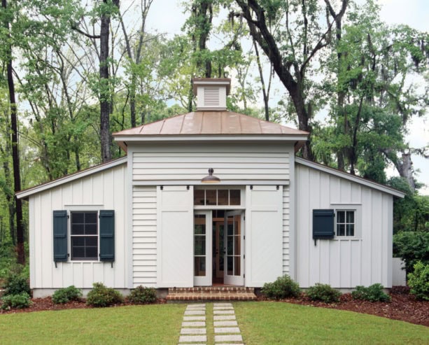 white sliding exterior barn door with an upper brace as the main entrance of a tropical house