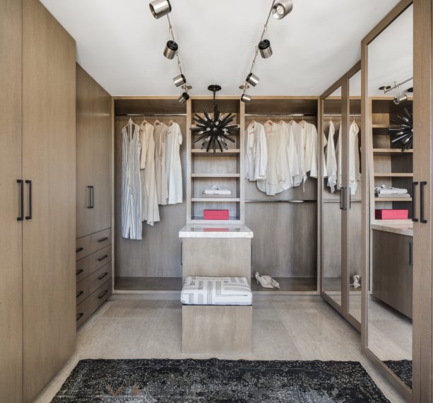 track lighting in brushed nickel to illuminate a mid-century walk-in closet