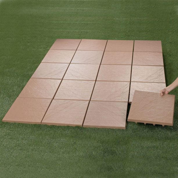 installing interlocking patio tiles on a flat-surface grass