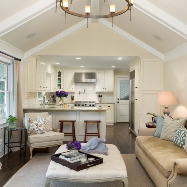 crisp white small peninsula kitchen and classic living room combo