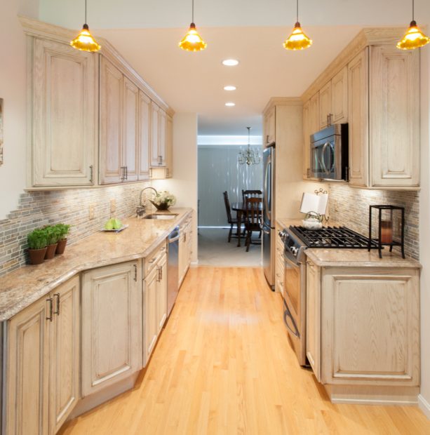 distressed white kitchen cabinets with a multicolored stone backsplash as an accent