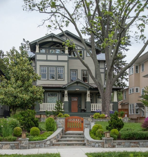 dark green window trim in a different thickness combined with light green siding in a craftsman-style exterior house