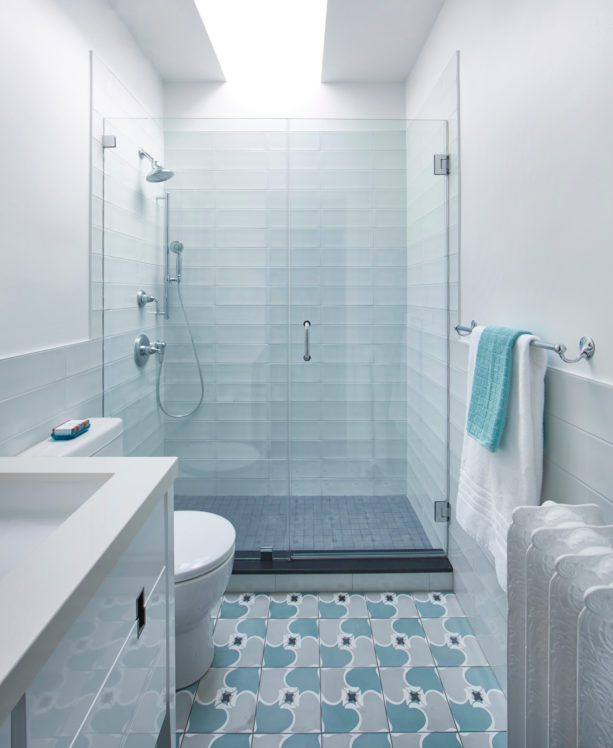 a transitional bathroom with pale blue ceramic tiles and white wall