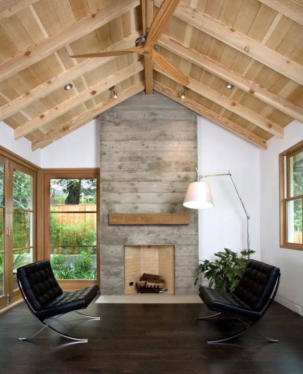 gray concrete mid-century modern fireplace with barn mantel