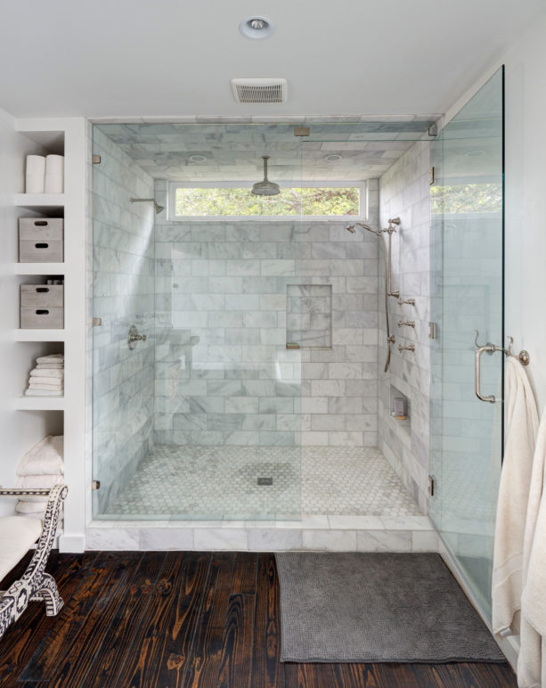 alcove shower in a contemporary white-tiled master bathroom without a tub