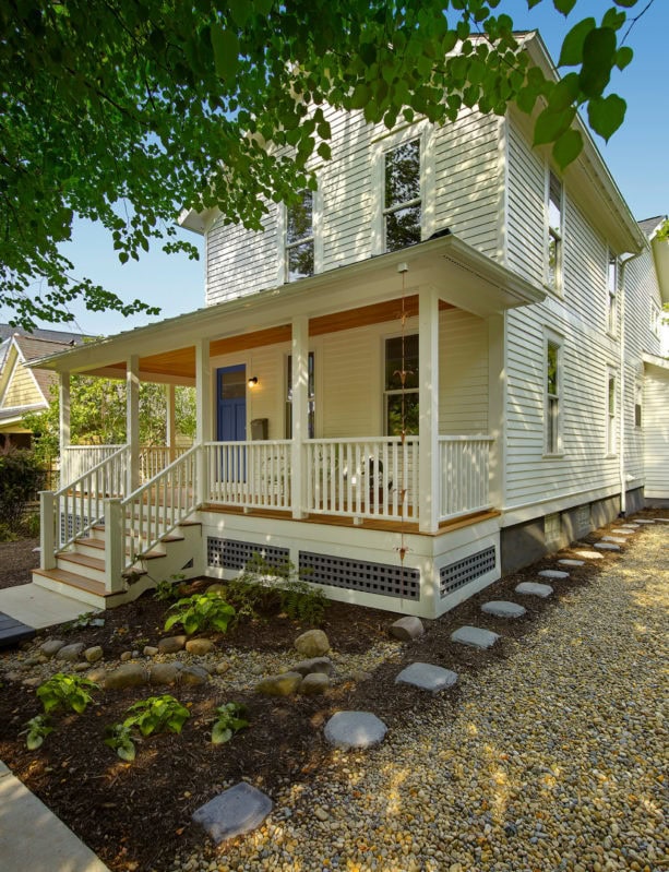 traditional front porch with stairs and deck in a two-story ranch style home