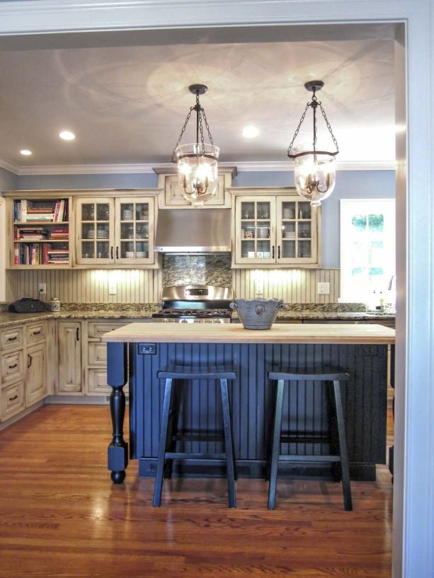 white distressed glass front kitchen cabinet with a blue island as an accent