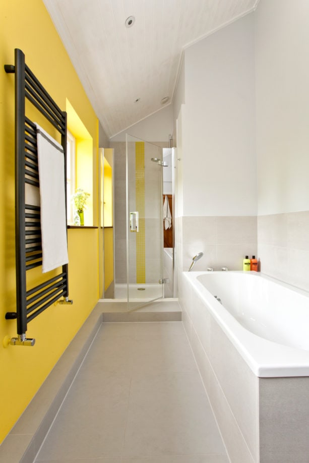 a grey contemporary bathroom with yellow accent wall