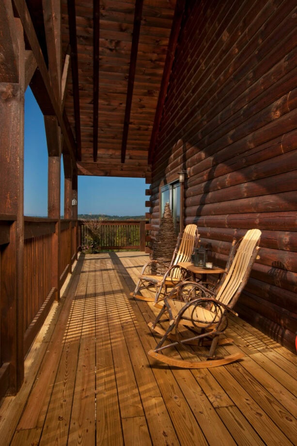 long and narrow log cabin porch with rustic furniture