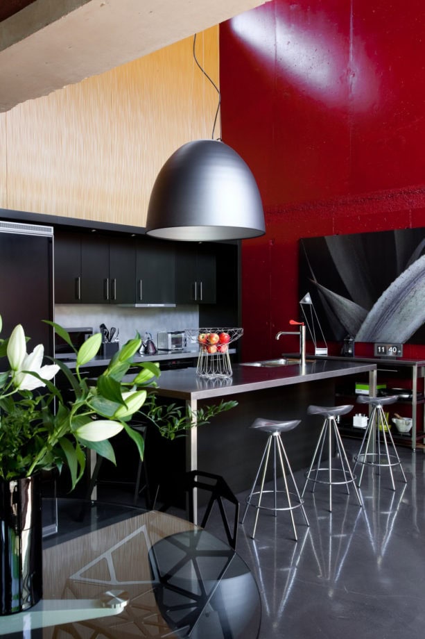 a stunning red accent wall in a black contemporary kitchen