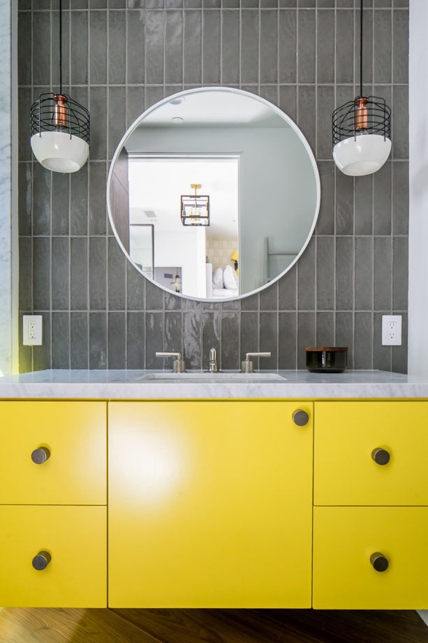 a floating flat-panel vanity cabinet paired with grey vertical glass subway tile for a color shot