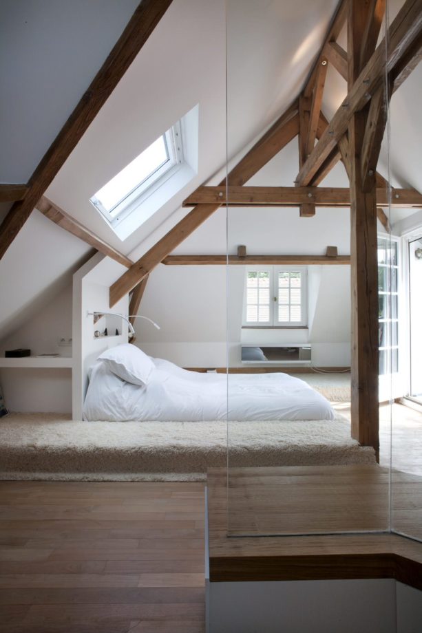 unique mid-sized attic bedroom with medium tone accent slanted walls