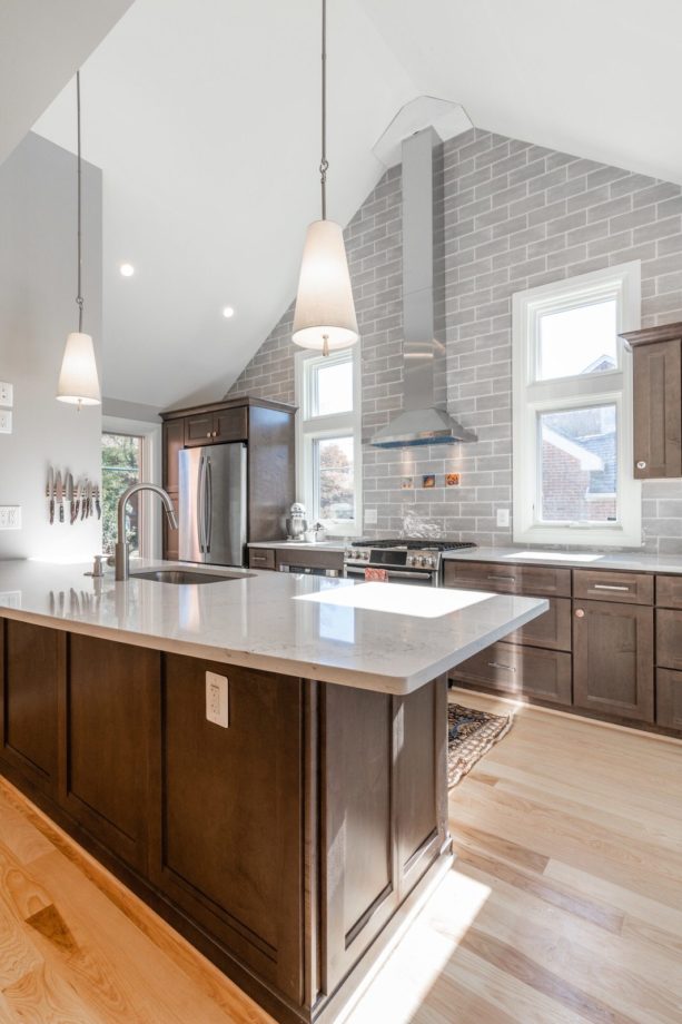 grey subway tile backsplash kitchen color mixes nicely with brown recessed-panel cabinets for a more open look