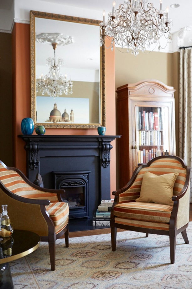 carrot orange wall and midnight blue fireplace as a focal point in a traditional living room