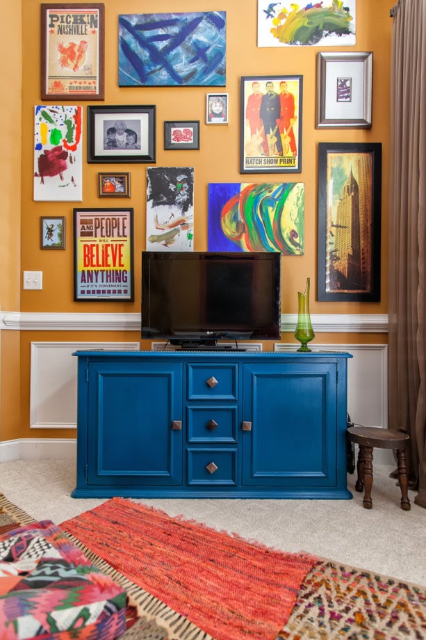 fun and eclectic living room with apricot orange wall and cobalt blue cabinet