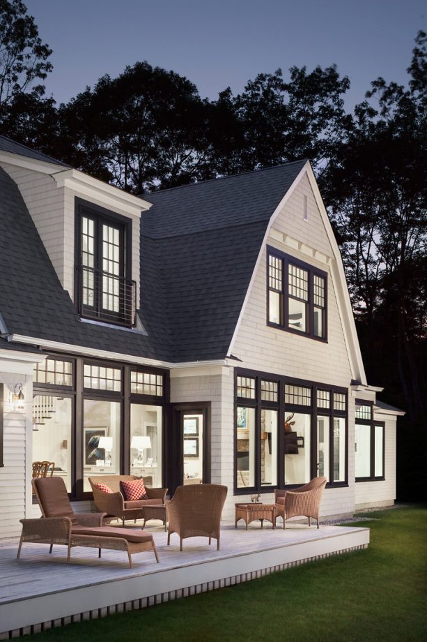 beach style house with a black gambrel roof with an off-white siding color