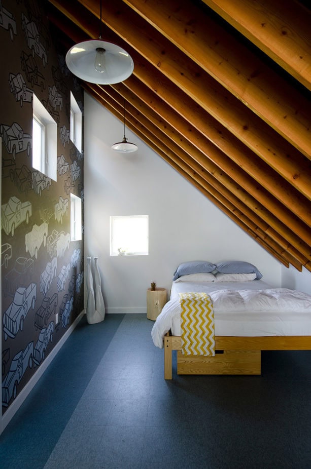 loft-style attic bedroom with mural paintings and wood slanted walls