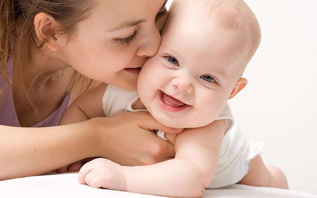 Mom kisses her baby