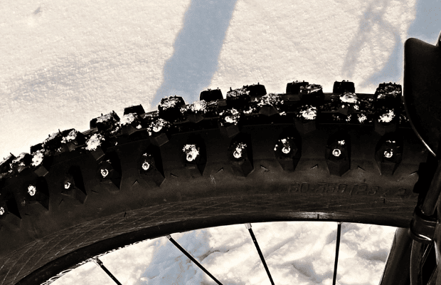 Knobby tire of a bike lightly dusted in snow