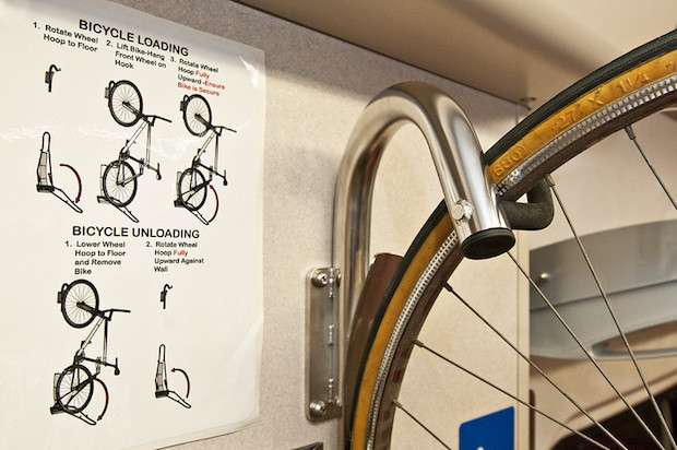 bicycle wheel hanging from a hook on a metro train
