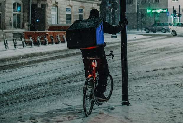 Cyclist holding a lamppost with a bike light on