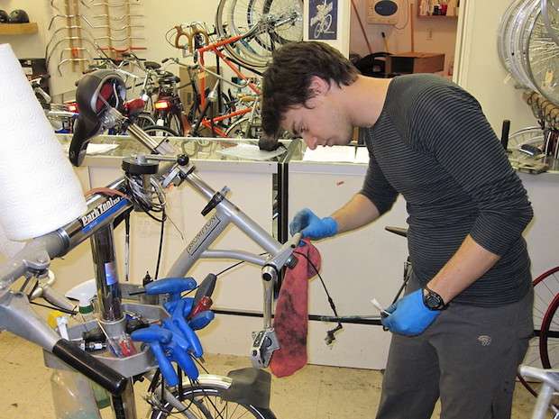 Mechanic in a bike shop cleaning a folding bike