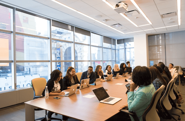 A team in an office discussing customer reference management during a meeting