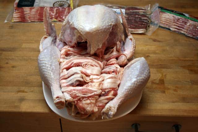 raw turkey stuffed with bacon-wrapped chicken and duck