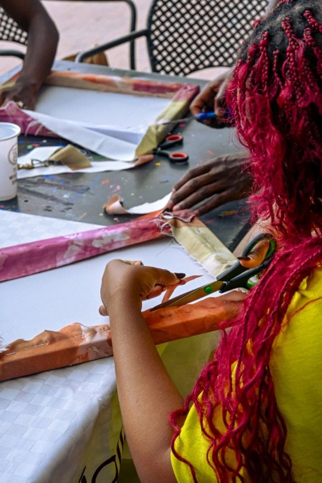 Participant cuts fabric strips during the hands-on Frame and Fabric Workshop at Galleria Shopping Mall.