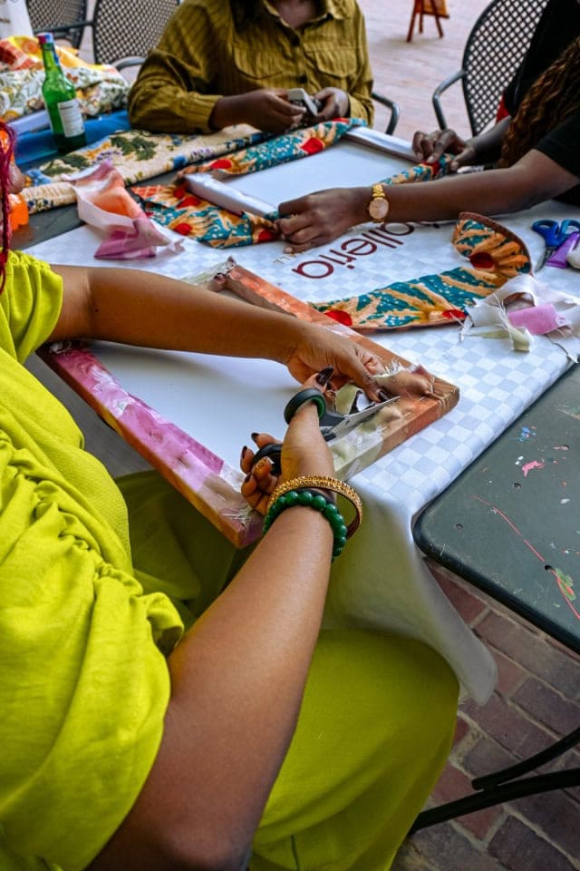 Several participants collaborate on colourful frame and fabric projects around a workshop table at Galleria.