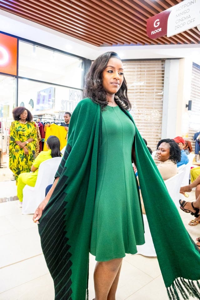 A model showcases a flowing emerald green outfit during the Style, Shop & Sip fashion presentation