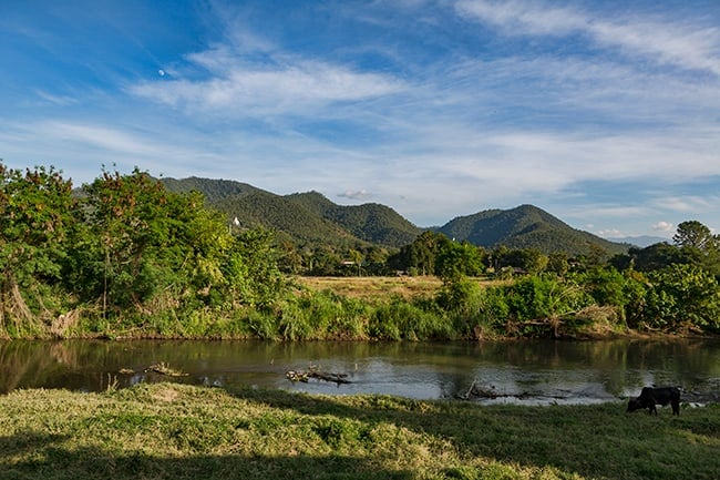 Pai river with the big Buddha in the mountain