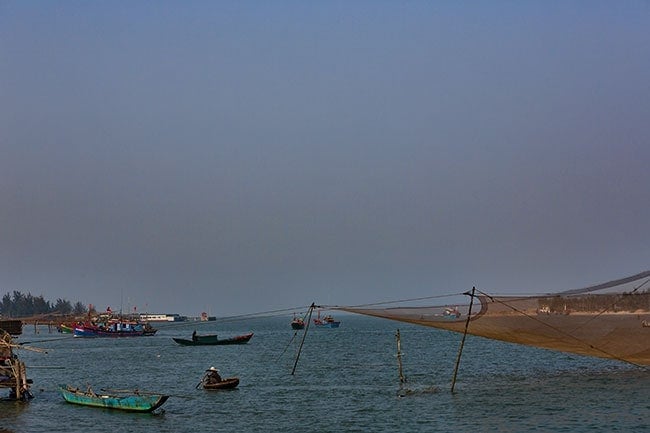 A fisherman paddles back to his hut