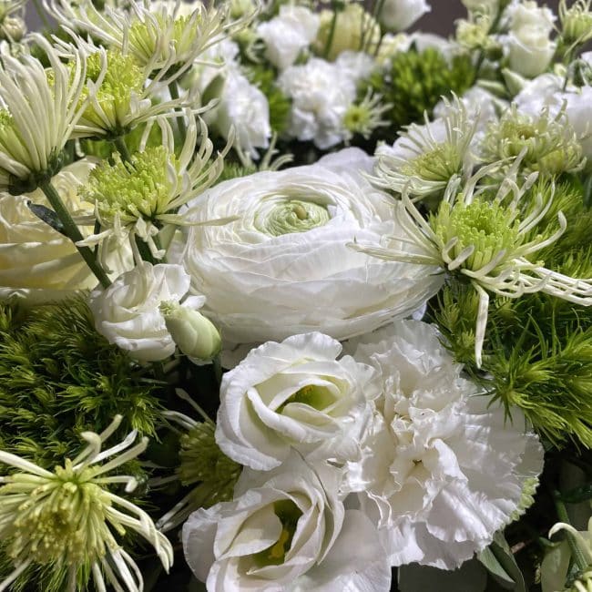 Trauerfloristik aus Paffenhofen Urnenkranz Frühling in weiss und grün mit Rose, Nelke, Lisyanthus, Chrysamthemen, Ranunkel - Nahaufnahme