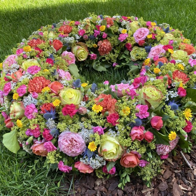 Moderner Trauerkranz - so bunt wie das Leben mit blauen Disteln - Mannstreu, Farbige Freiland Rosen, Frauenmantel, Schafgabe, pinke Nelken, gelbe Färberkamille, Preis ca. 380 Euro