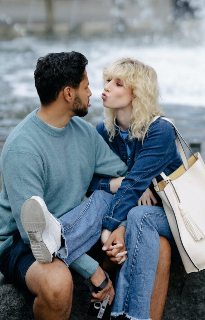 man kissing woman in jacket