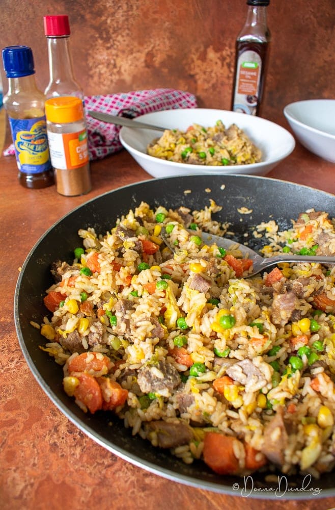 fried rice in frying pan with serving spoon.