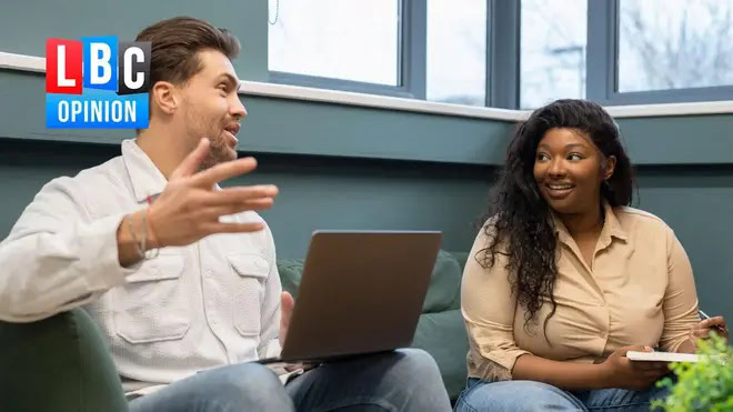 Alamy stock image of two people sat on a couch talking one has a laptop and is gesturing with thweor hand in the top left corner the LBC opinion logo