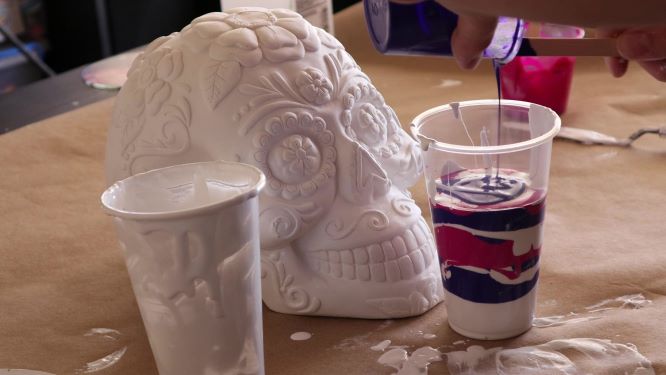 sugar skull art in progress, pouring paint on top of