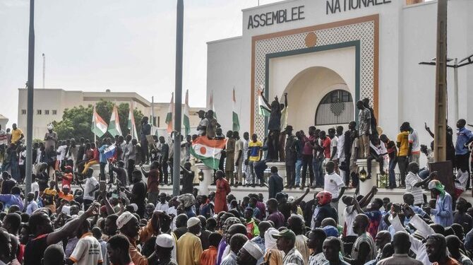 Supporters wave Nigerien’s flags as they rally in support of Niger’s junta in front of the National Assembly in Niamey on July 30, 2023. (AFP)