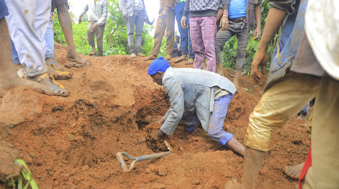 In this handout photo released by Gofa Zone Government Communication Affairs Department, a man searches for survivors hundreds of people gather at the site of a mudslide in the Kencho Shacha Gozdi district, Gofa Zone, southern Ethiopia, Monday, July 22, 2024. At least 146 people were killed in mudslides in a remote part of Ethiopia that has been hit with heavy rainfall, according to local authorities. (Gofa Zone Government Communication Affairs Department via AP)