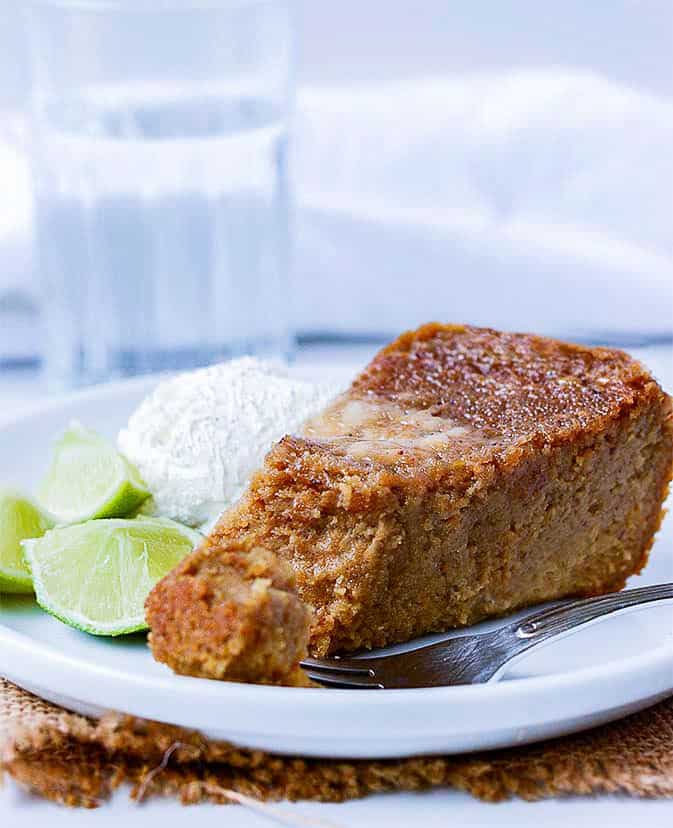 sweet potato pudding slice on white plate with lime slices