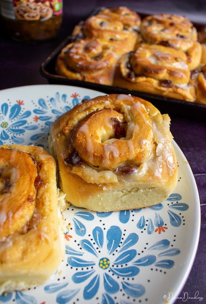 Mincemeat Chelsea bun on a patterned plate, other buns in background