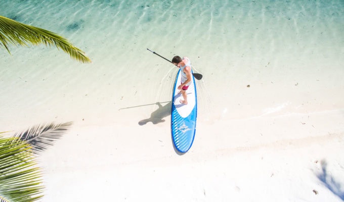 Man getting ready to surf on an inflatable stand up paddle board