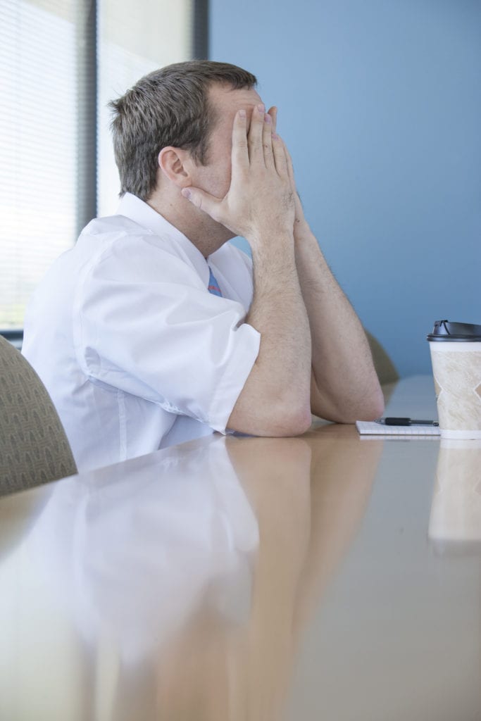 Stressed person sitting at an office desk, representing the challenges of managing stress in the workplace or in his marriage