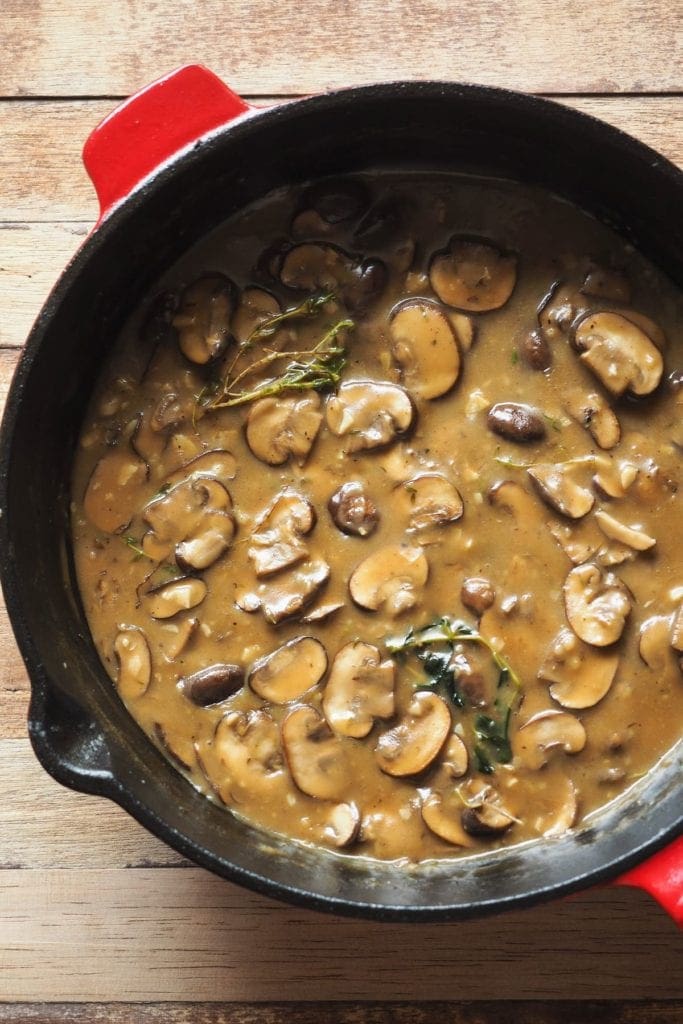 Esta receta de Judías Verdes con Salsa de Champiñones sin lactosa es un súper acompañamiento! Cremosa, ligera y lista en menos de 20 minutos, es un éxito garantizado! En la foto se ve una sartén con la salsa de champiñones.